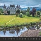 April. Eine Burg steht auf einem grünen Feld, umgeben von Bäumen und einem Fluss im Vordergrund.