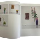 Texte: "The Original Cast", "Confines (Our True Conscience)". 

Eingerahmte Ohrenreliefs über Vasen mit Blumen.
