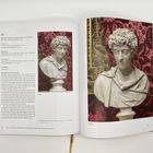 Seite aus einem Buch mit einem Text über eine Marmorbüste von Caesar Marcus Aurelius, daneben ein Bild der Büste vor rotem Hintergrund.