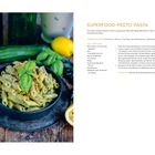 "SUPERFOOD-PESTO-PASTA" mit Rezept. Links Nudeln mit grüner Sauce und Basilikum in einer Schale, darum herum Zucchini, Zitrone.