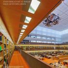 Staatsbibliothek zu Berlin, Haus Unter den Linden. Moderner Lesesaal mit Bücherregalen, Deckenleuchten und hängender Skulptur.