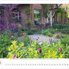 Text: „1 2 3 4 5 6 7 8 9 10 11 12 13 14 15 16 17 18 19 20 21 22 23 24 25 26 27 28 29 30“. 

Idyllischer Garten vor einem Backsteinhaus mit bunten Blumen und grüner Vegetation.