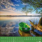 Zitat: "Wahrer Reichtum besteht nicht im Besitz, sondern im Genießen." Ein grünes Boot an einem Seeufer unter blauem Himmel.