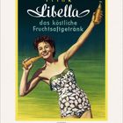 „Trink Libella, das köstliche Fruchtsaftgetränk.“ Eine Frau im Badeanzug hält eine Getränkeflasche, fröhlich lächelnd.