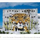 Zahlen von 1 bis 30, darunter eine große Wandmalerei eines Leopardenkopfes auf einem grauen Gebäude, umgeben von Bäumen.