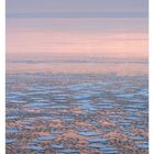 03 JANUAR. Ein Sonnenuntergang über einer eisbedeckten Ostsee mit rötlichen und blauen Farbtönen.