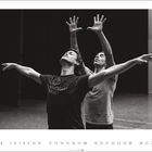 "Tanzende Männer mit erhobenen Armen. T-Shirt: 'STUTTGART BALLET'. Kalenderdaten unten mit einer 4 links."