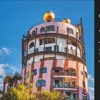 Besondere Stadoase. Samstag, 3. April. Ein rundes, fantasievoll gestaltetes Gebäude mit goldenen Kuppeln und vielen Fenstern.