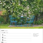 Juni, 23. Woche, Zwillinge 21.5.–20.6. Kalenderwoche: 7.–13. Montag bis Sonntag. Zwei blaue Gartenstühle vor Rosenbusch.