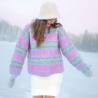 Keine Texte vorhanden. Eine Frau in pastellfarbiger Winterkleidung steht im Schnee, umgeben von verschneiter Landschaft.