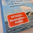 Text: „Eine Familie auf großem Segelabenteuer“ und „SPIEGEL Bestseller-Autor“. Szene: Tropische Küste mit Segelboot.