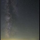 Sternenklare Nacht über einem Hügelpanorama, die Milchstraße erstrahlt majestätisch am dunklen Himmel.