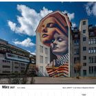 März 2027, 10./11. Woche. Mural „IDENTITY“ in Wuppertal-Elberfeld. Zwei überdimensionale Gesichter an einer Hausfassade.