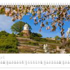 "April", "Jacobstein". Kalenderdarstellung. Blühende Bäume rahmen einen Hügel mit kleinem, rundem Gebäude oben ein.