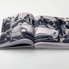 Zwei Buchseiten zeigen ein Team, das ein Auto betrachtet und bearbeitet, die Szene wirkt konzentriert und technisch.