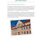 92. Grundschule und Hort „An der Aue“ in Dresden, saniert. Foto: Beige Schulgebäude mit rotem Dach unter blauem Himmel.