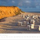 April 2027, Sylt - Leuchtturm, Kalender. Strand mit Strandkörben, rotes Kliff im Hintergrund, Meer rechts.