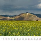 Kalender für April 2027, Siebengebirge, gelbes Rapsfeld, Drachenfels und Schloss im Hintergrund unter bewölktem Himmel.