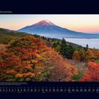 "11 November" steht oben links. Darunter Herbstbäume in Rot und Gelb, dahinter ein Berg mit schneebedecktem Gipfel. Kalenderansicht.