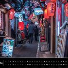 Kalendarium für April, Ort: Omoide Yokocho, Shinjuku, Tokio. Eine belebte Gasse mit leuchtenden Laternen und Menschen.