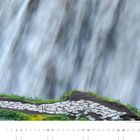 04. Kalender mit Steg und Person in Rot vor Wasserfall.