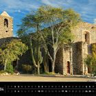 "Mexiko 04" unten links, Monatskalender April, Mission Santa Rosalía, Mulegé. Steinbau, Glockenturm, Kakteen, Bäume, blauer Himmel.