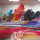 Eine bunte Wandinstallation mit verwaschenen Farben in Rot, Blau, Schwarz und Lila, kunstvoll angeordnet.