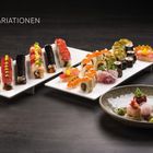SUSHI-VARIATIONEN. Eine Auswahl bunter Sushirollen in verschiedenen Formen und Farben auf modernen Platten angerichtet.