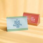 Vorne: „Auf die Plätze, glücklich, los! 2027“, pastellblauer Tischkalender. Hinten: „Wer A sagt, muss auch B sagen“, in Rot.