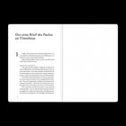 Eine geöffnete, leere weiße Buchseite auf schwarzem Hintergrund.