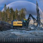 Kalender mit Wochentagen und Zahlen 1–30. Ein gelber Bagger, auf einer Baustelle, unter einem Regenbogen und Tannen im Hintergrund.