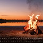 Kalender mit April-Übersicht. Im Vordergrund brennendes Lagerfeuer, dahinter ein See bei Sonnenuntergang.