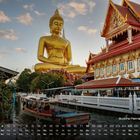 Buddha Paknam Tempel 4. Großes Buddha-Abbild und buntes Gebäude am Wasser, umgeben von grüner Landschaft und Booten.