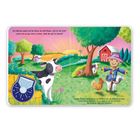 Ein Kälbchen spielt auf grüner Wiese. Ein schwarzes und weißes Rind steht nahe. Sonnenuntergang im Hintergrund.