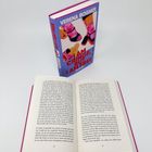 Auf einem Tisch steht ein geschlossenes Buch mit dem Titel „I AM CRINGE, BUT I AM FREE“ und ein aufgeschlagenes Buch.