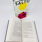 Zwei Bücher: Eines geschlossen mit dem Titel "SALTO", gelbem Kreis, und ein offenes zeigt die Seiten 102 und 103 auf weißem Hintergrund.