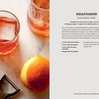 "Boulevardier: Bitter, Aromatic, Woodsy. Zutaten: Bourbon, Campari, Vermouth. Orangenzeste zur Garnierung."  
Links ein Glas, Orange und Schäler auf Marmor.