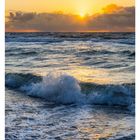44 November, Sonnenuntergang über der Ostsee. Wellen brechen unter einem orangefarbenen Himmel.