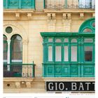 Text: GIO. BATT., 18 Mo, 19 Di, 20 Mi, 21 Do, 22 Fr, 23 Sa, 24 So, 42. Woche 2027, OKTOBER. Grünes Gebäude mit Balkon.