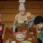 Vier Personen sitzen um einen Tisch, trinken und essen gemeinsam in einem traditionell eingerichteten Raum.