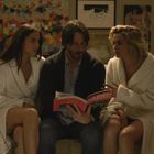 "Karen Alvarado" auf einem Buchumschlag. Drei Personen auf einem Sofa, in weiße Bademäntel gehüllt, umgeben von Kunstwerken.