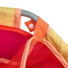 Farbenfroher Stoff mit einem Netzgewebe, das an einem grauen Henkel mit orangenen Knöpfen befestigt ist.