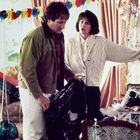 Ein Mann und eine Frau stehen in einem festlich dekorierten Raum mit Ballons. Die Stimmung wirkt angespannt.