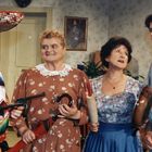 Vier Personen in einem Raum: Ein Mann mit Sombrero, eine Frau mit Schirm, eine Frau mit Nudelholz und ein junger Mann.