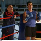 Zwei Männer im Boxring: Einer trägt blaue Handschuhe mit "Everlast" Aufschrift, der andere einen Trainingsanzug.
