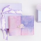 Drei pastellfarbene Geschenke: eines mit lila Schleife, eines rosa-blau, eines mit flauschiger Schleife in Rosa und Blau.