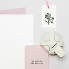 "GO BEYOND THE HORIZON" steht auf einer rosa Karte; Zubehör für Papierdekoration und ein Etikett mit Blumenillustration.