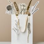Eine weiße Tüte mit naturinspirierten Illustrationen von Pflanzen mit braunen und schwarzen Details und zwei Tragegriffen.