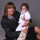 Ich kann keine Personen erkennen, aber eine Frau hält ein Baby mit Flasche im Arm.