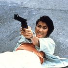 Ich kenne keine Texte im Bild. Eine Person liegt rücklings auf dem Boden und zielt mit einer Pistole.